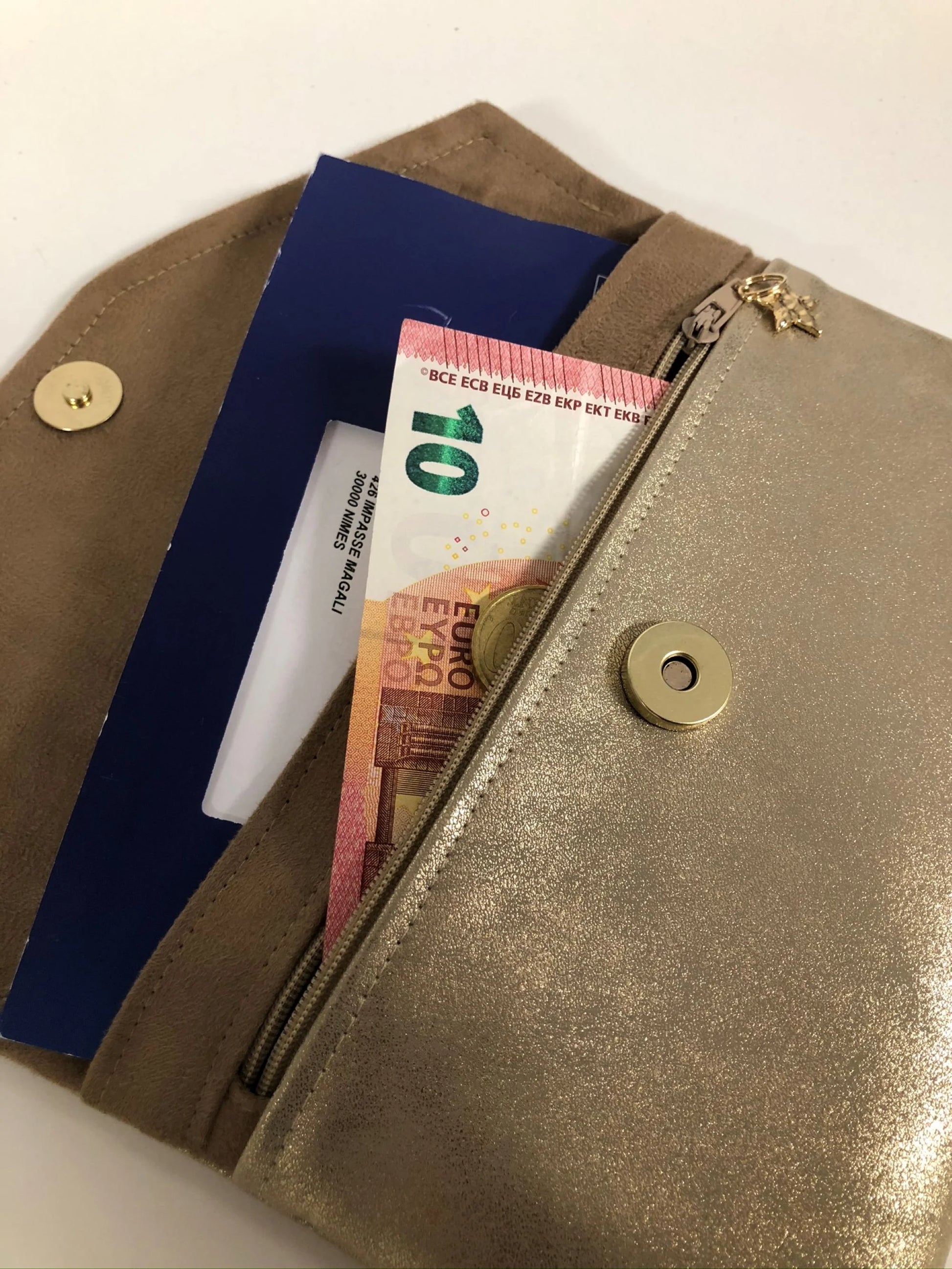 Le compagnon de sac beige et doré avec carnet de chèques et espèces.