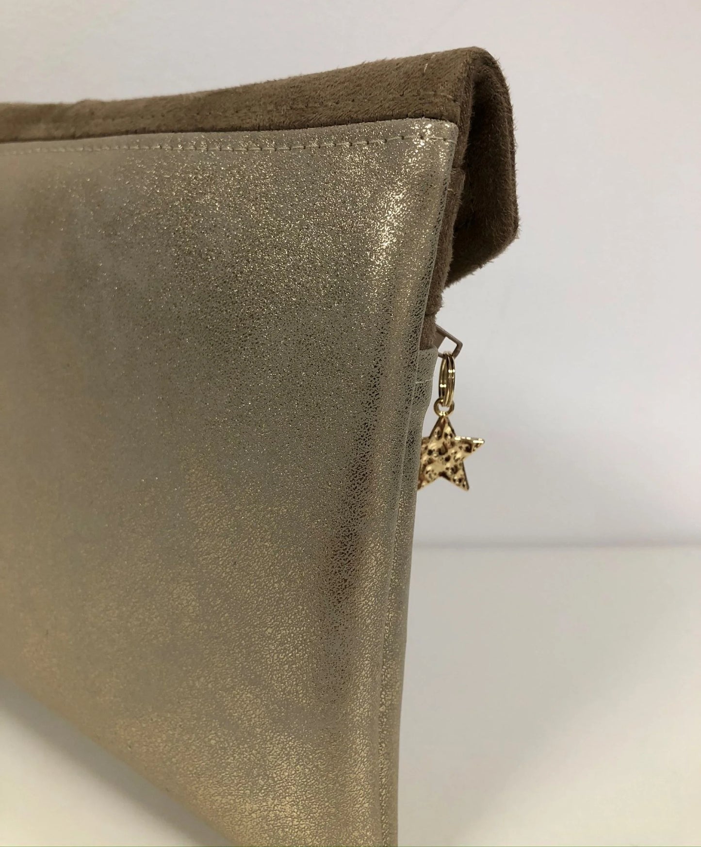La face arrière du compagnon de sac beige et doré.