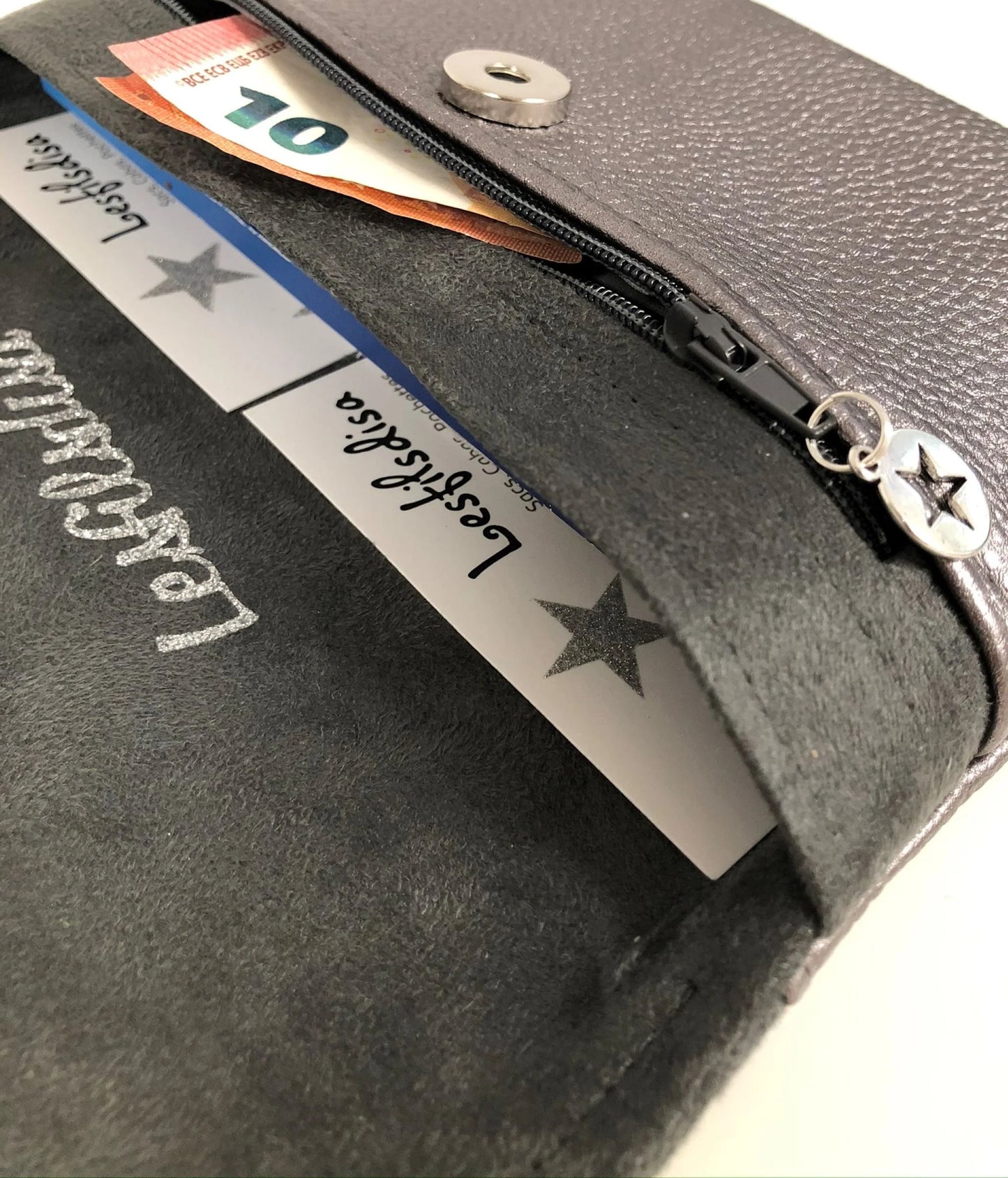 Le porte monnaie zippé ouvert du compagnon de sac gris irisé.