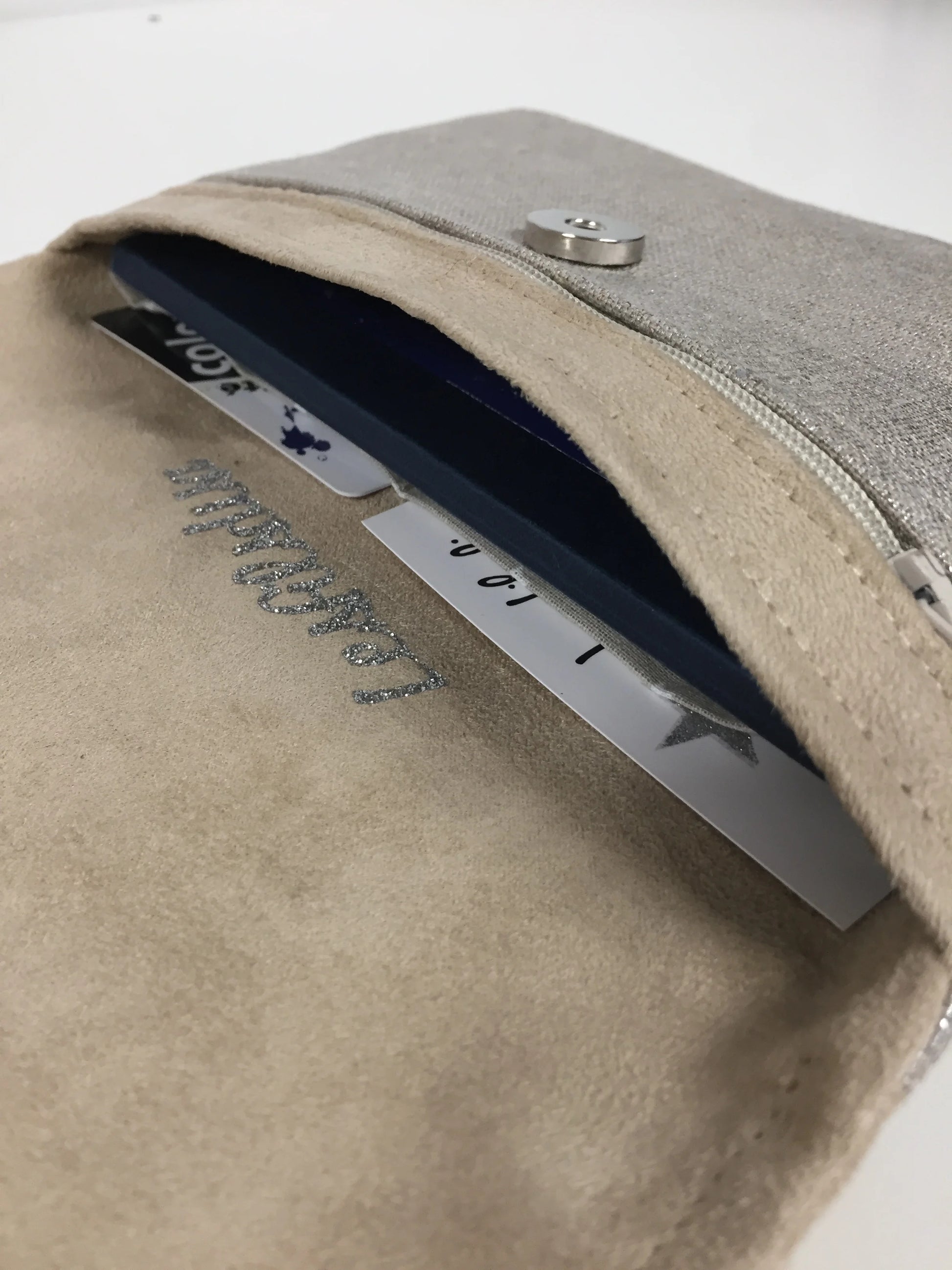 Le compartiment papiers et chéquier du compagnon de sac beige en lin argenté.
