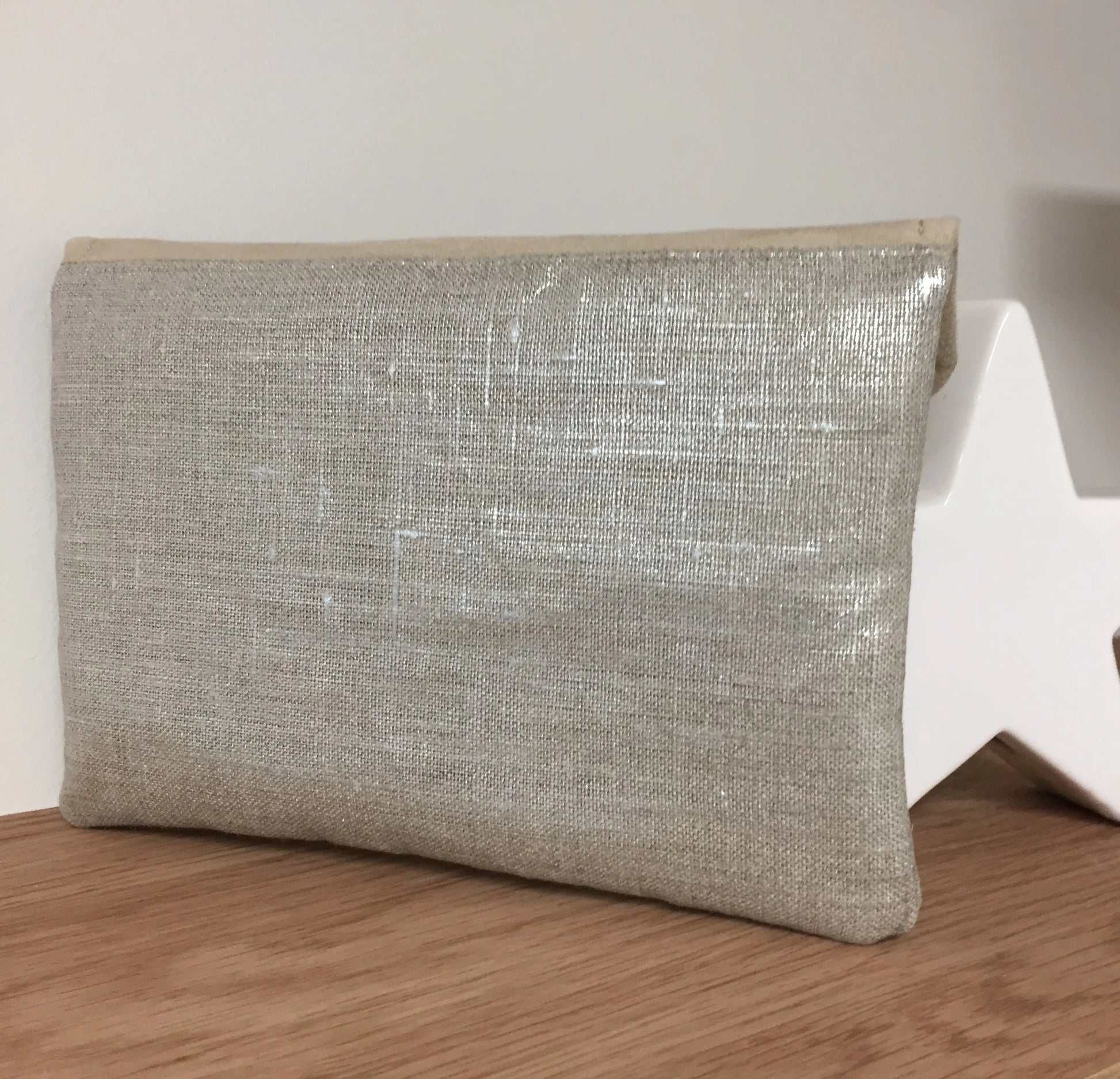 L'arrière du compagnon de sac beige en lin argenté.