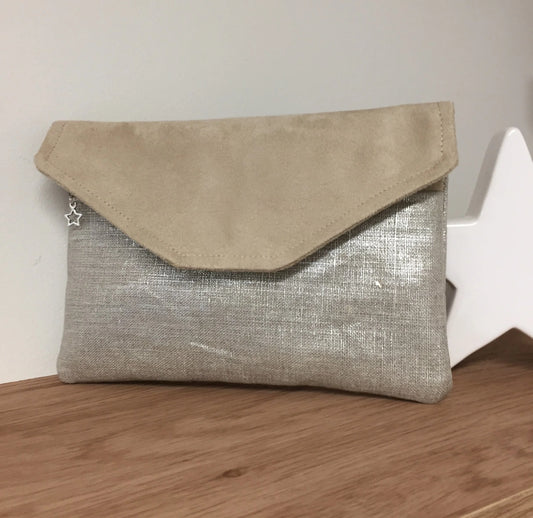 Le compagnon de sac beige en lin argenté, fermé par son rabat.