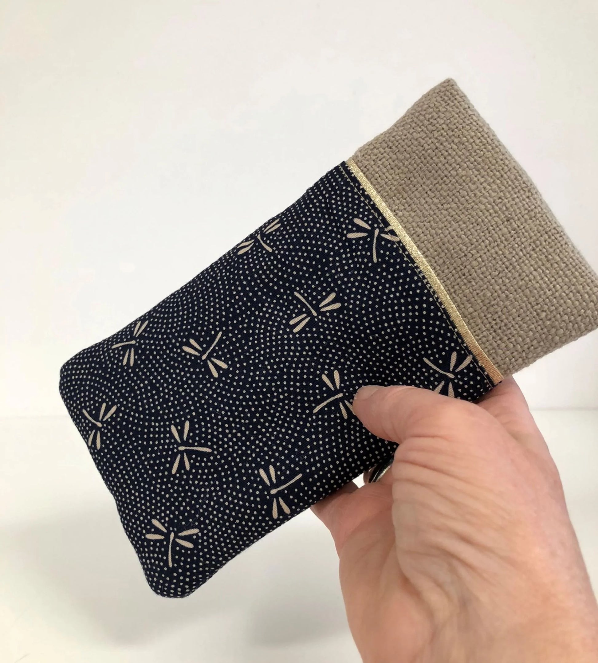 L'étui à lunettes en lin et tissu japonais Komon libellules bleu, tenu en main.