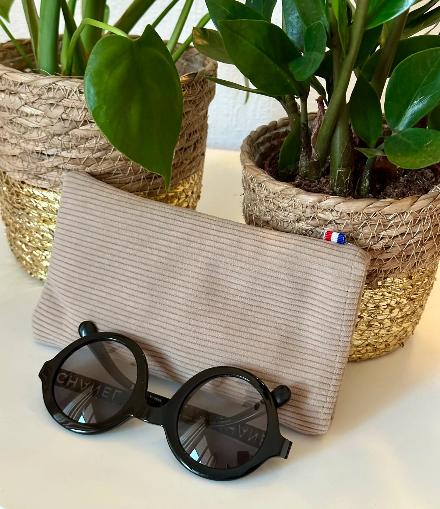 L'étui à lunettes en velours cotelé beige.