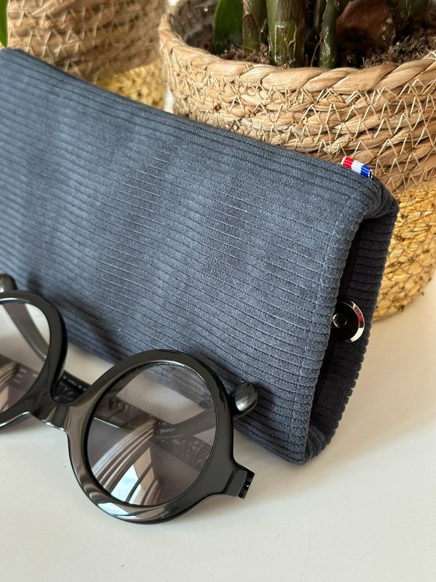 L'étui à lunettes en velours cotelé bleu canard, entrouvert.