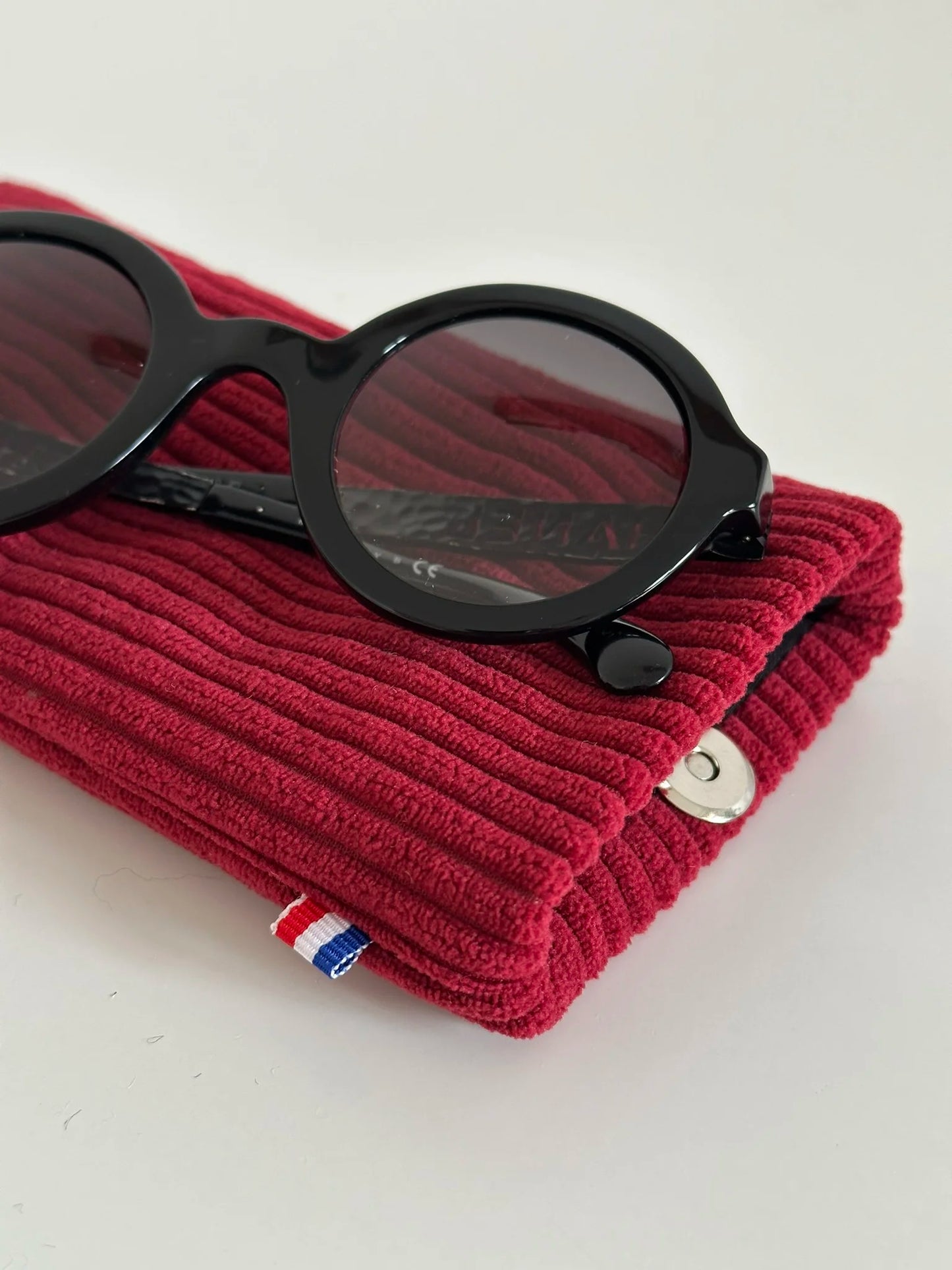 Vue détaillée de l'étui à lunettes en velours cotelé bordeaux.