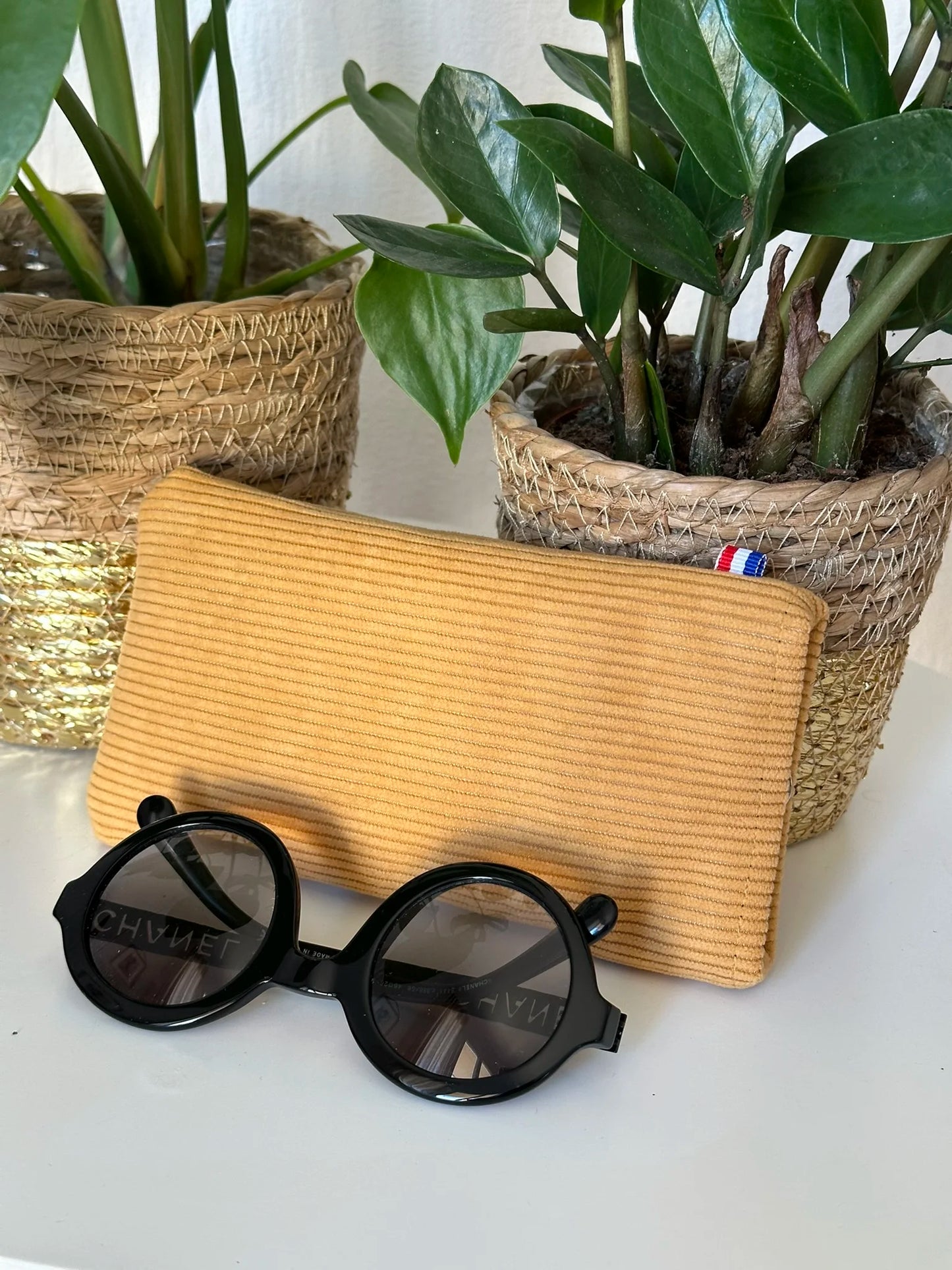 L'étui à lunettes en velours cotelé jaune moutarde.