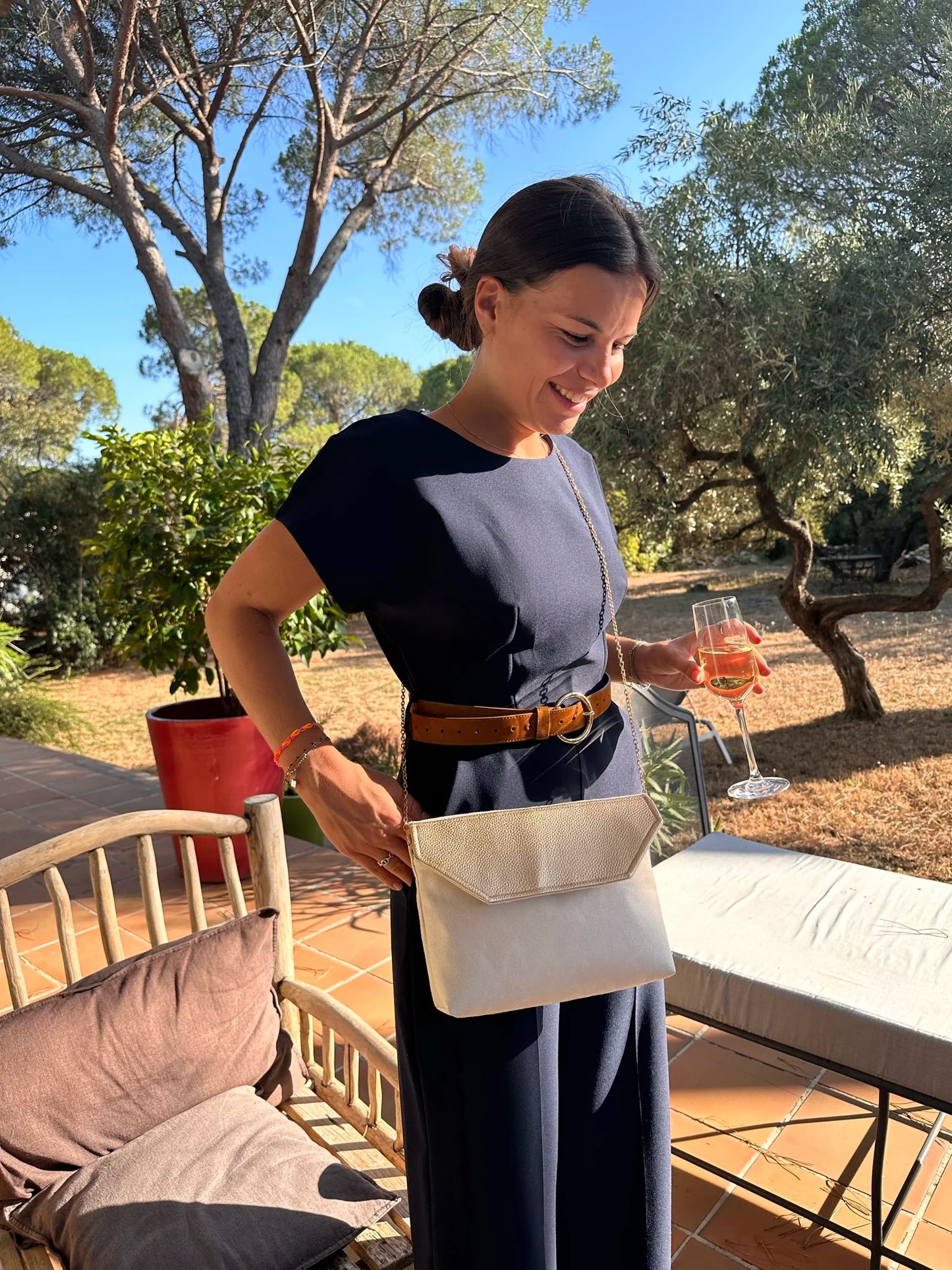 femme élégante qui porte la pochette Isa ivoire et dorée