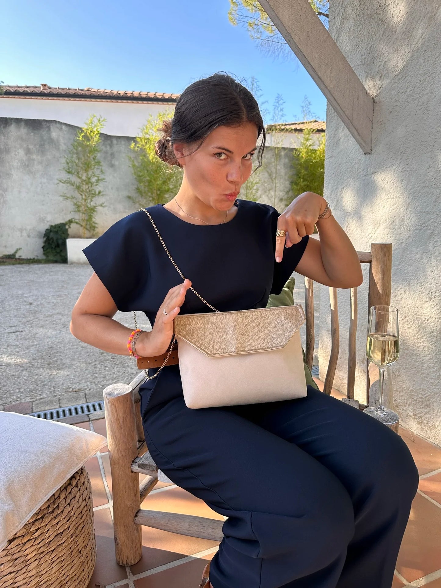 femme assise avec pochette Isa ivoire et doré sur ses genous