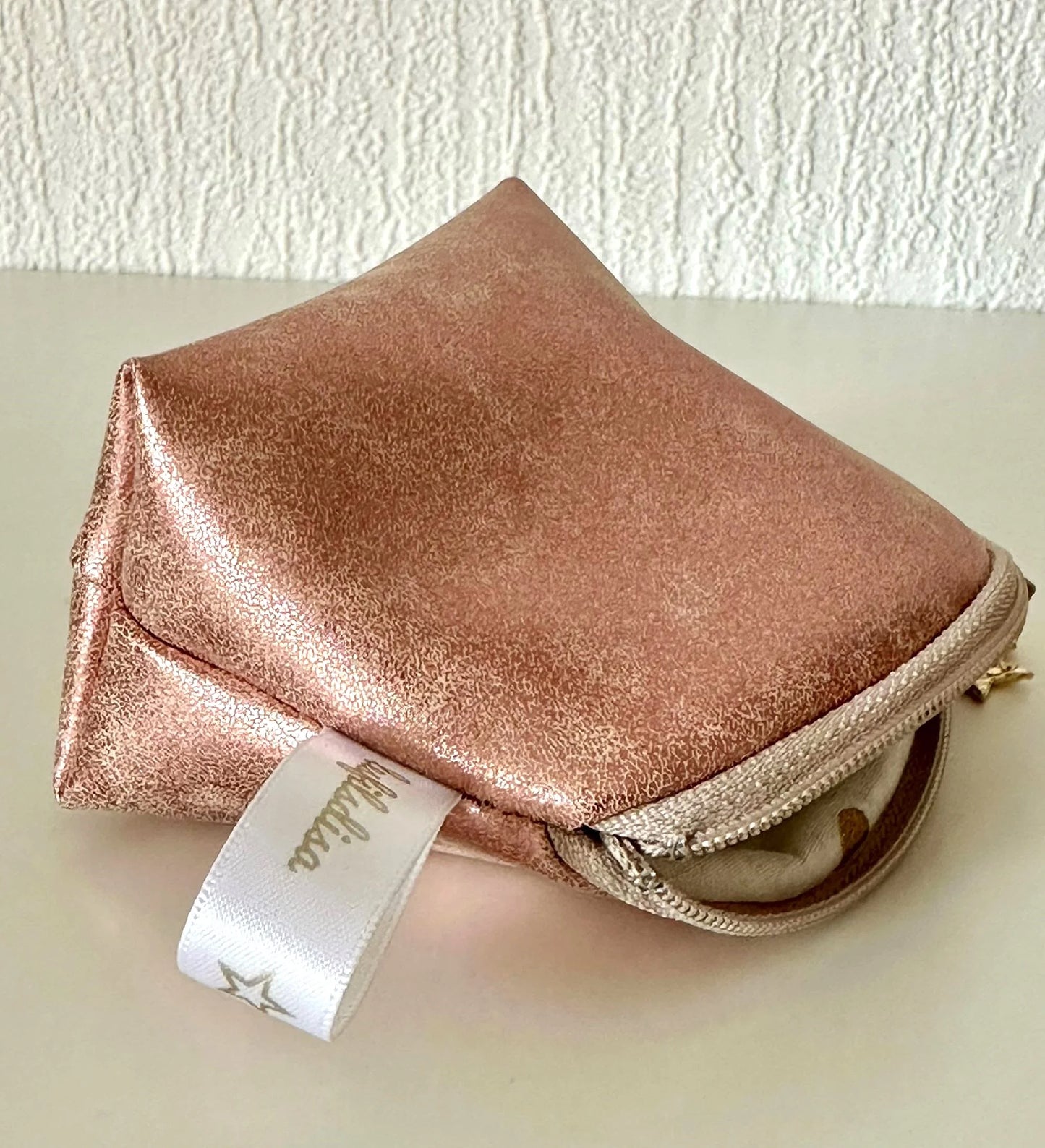 Vue latérale du petit porte-monnaie or rose.