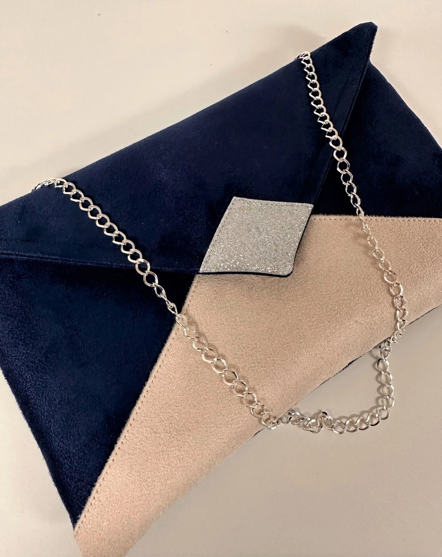 Détail de la face avant de la pochette Isa bleu marine et beige nude à paillettes argentées
