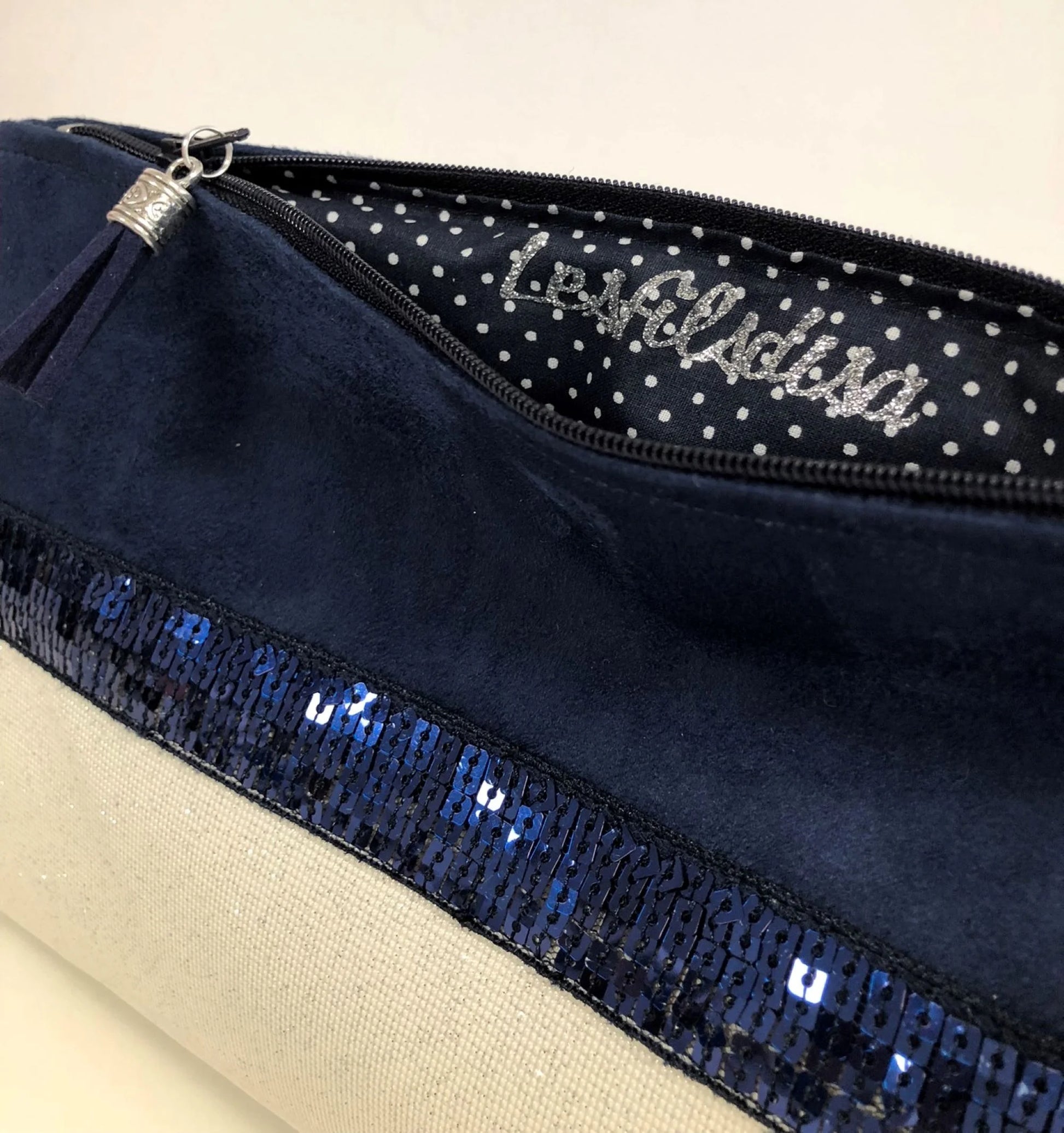 L'intérieur de la pochette Isa zippée bleu marine et blanc à paillettes .