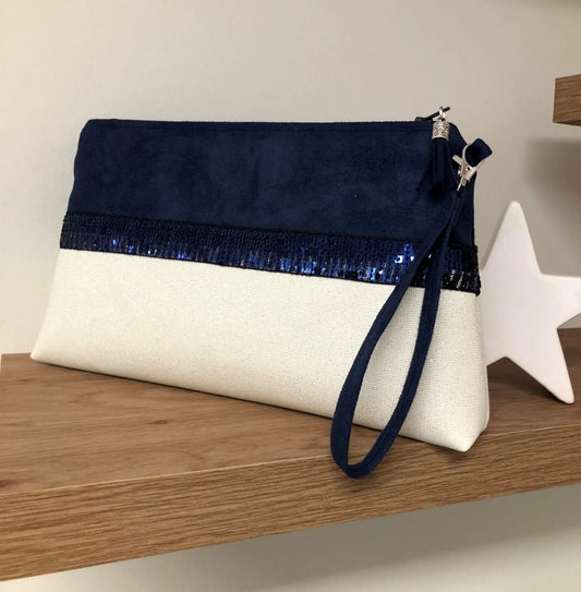 La pochette Isa zippée bleu marine et blanc à paillettes avec sa dragonne amovible pour le poignet.