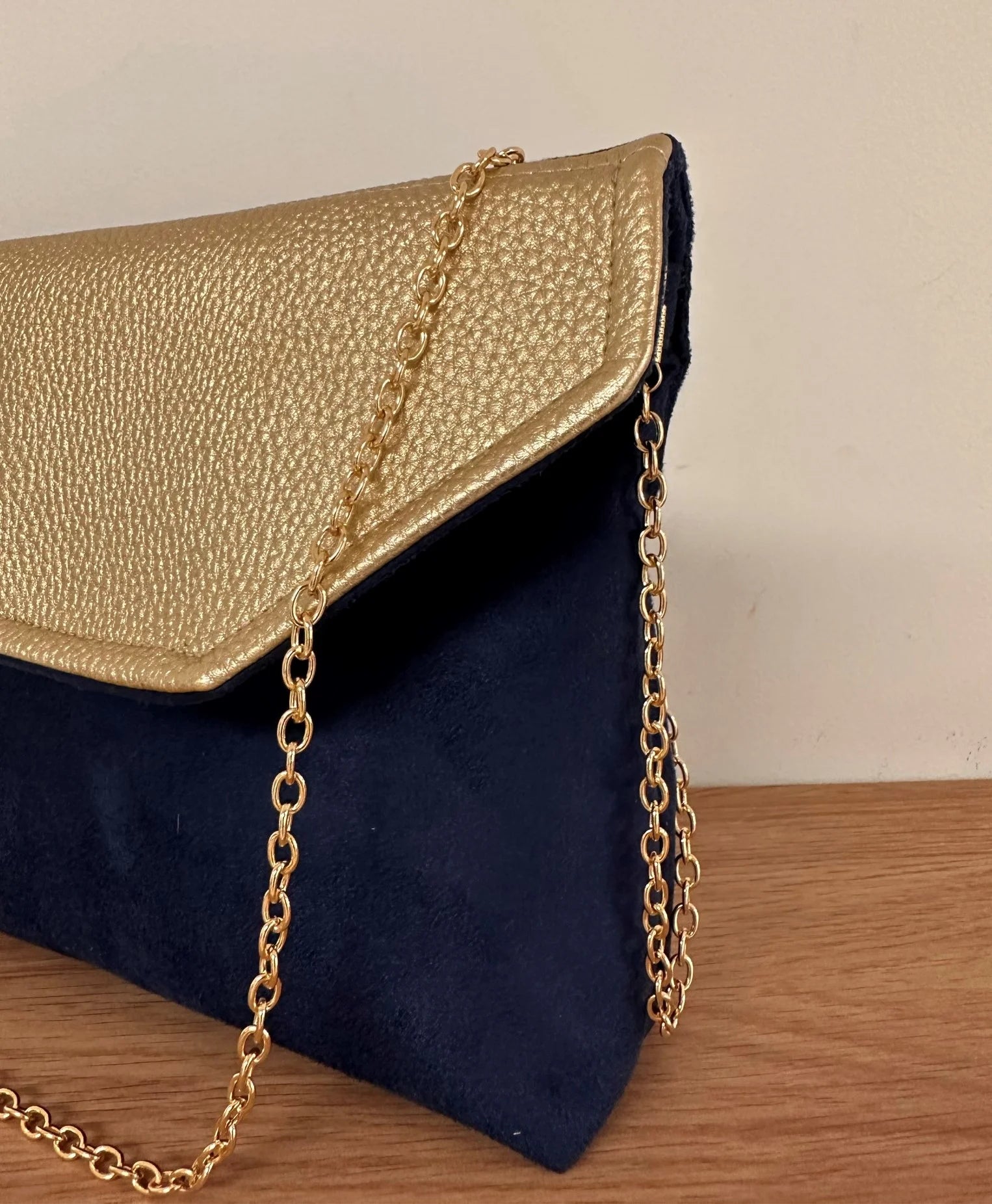 Vue de détail du rabat doré de la pochette Isa zippée bleu marine