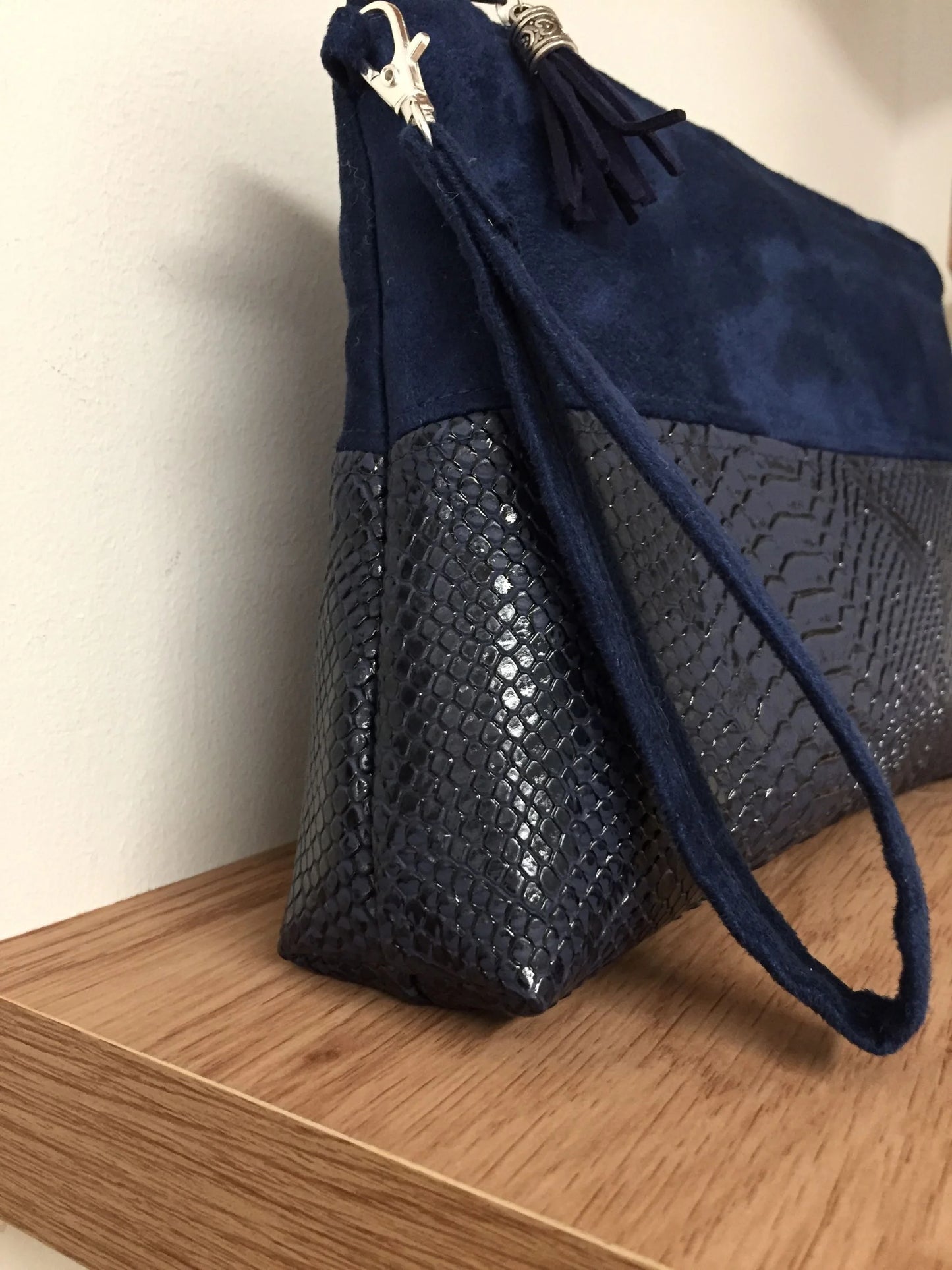 Vue latérale de la pochette Isa zippée bleu marine aspect reptile.