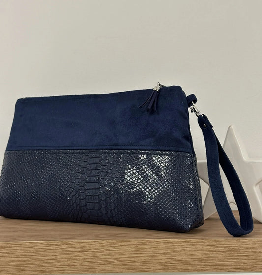 La pochette Isa zippée bleu marine aspect reptile, avec sa dragonne amovible.