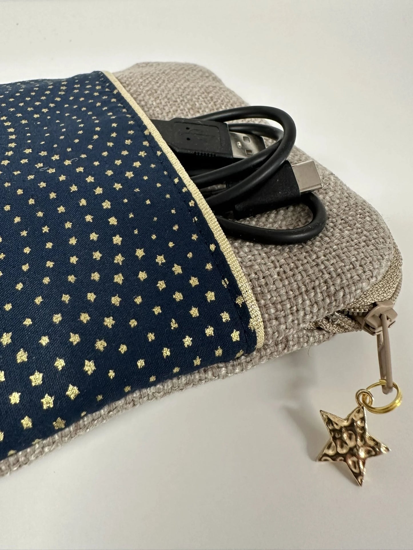 Vue détaillée de la poche avant de la pochette liseuse en lin et tissu bleu à étoiles dorées.