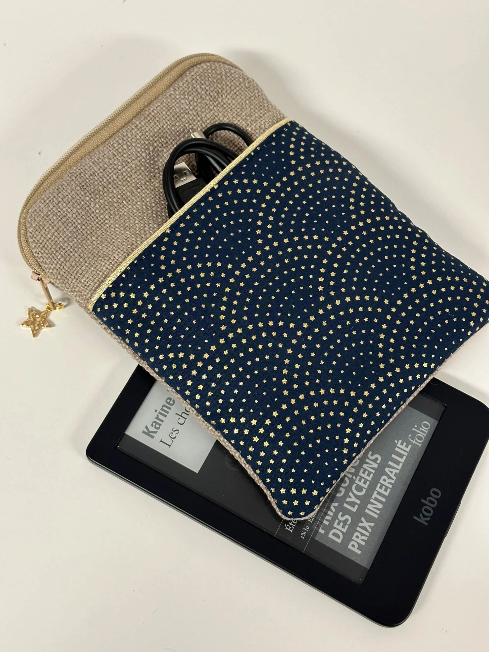 La pochette liseuse en lin et tissu bleu à étoiles dorées, présentée avec Kobo Clara.