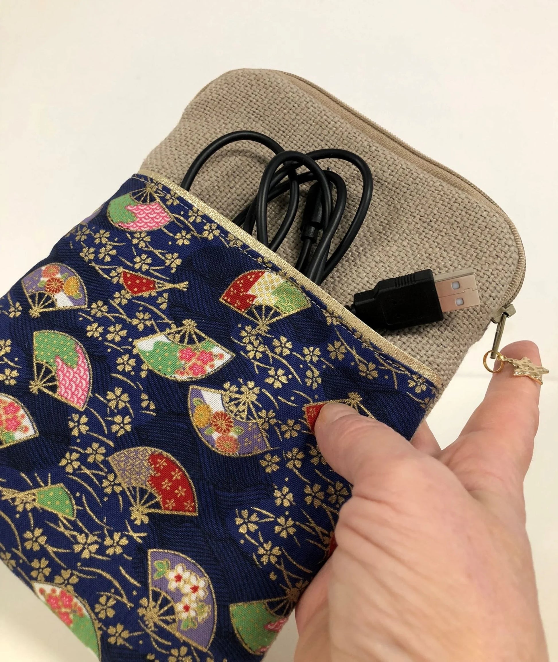 La pochette liseuse en lin et tissu japonais éventails tenue en main.