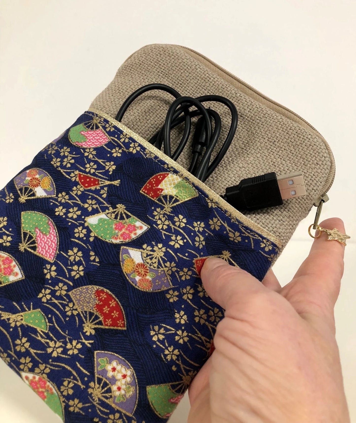 La pochette liseuse en lin et tissu japonais bleu éventails tenue en main