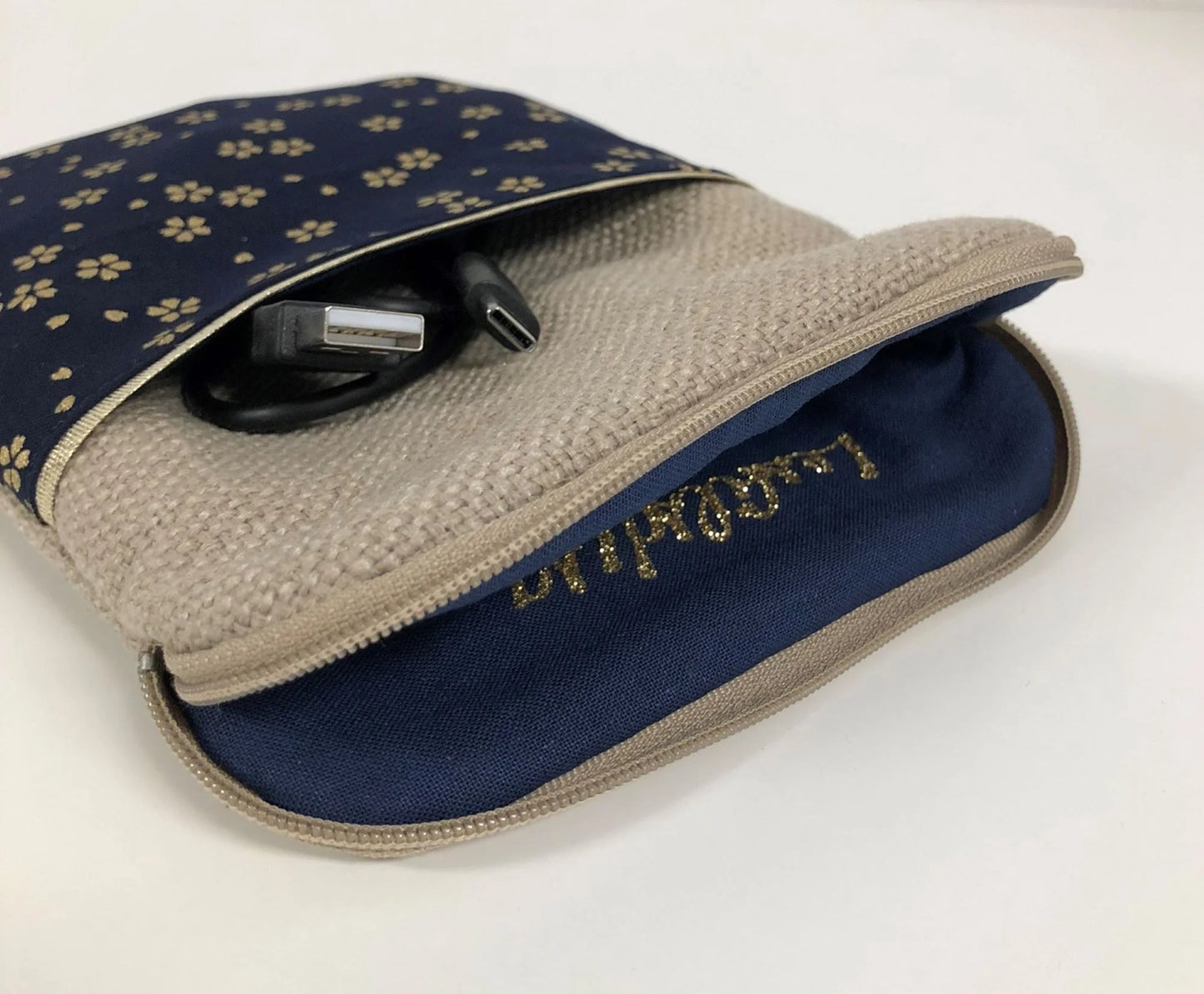 La pochette pour liseuse numérique en lin et tissu japonais bleu nuit à fleurs dorées, entrouverte