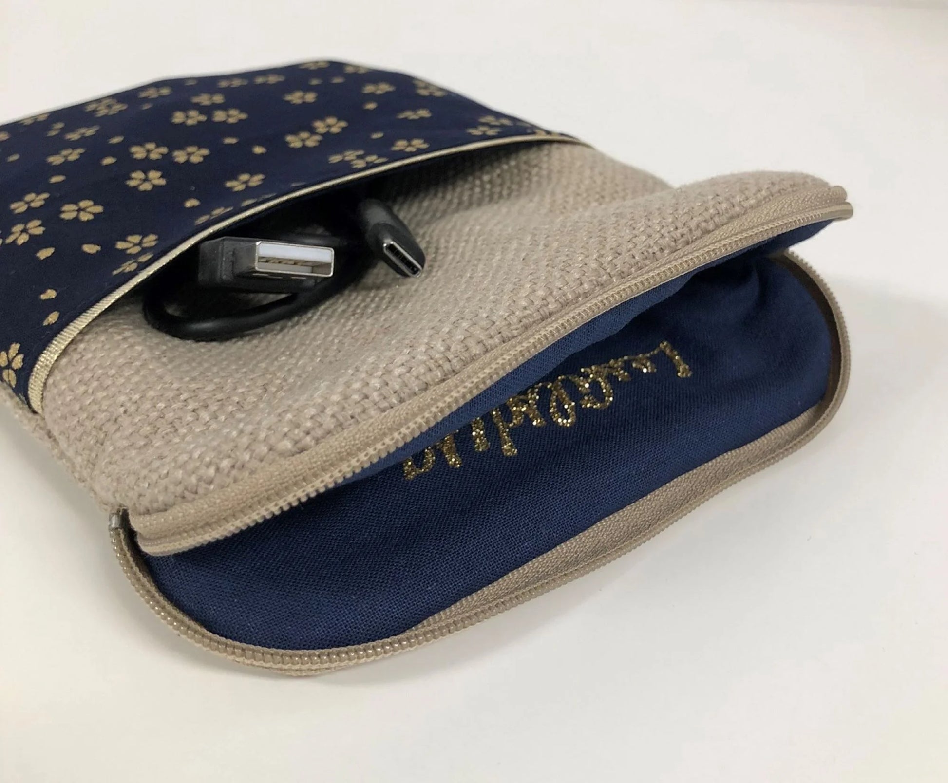 La pochette pour liseuse numérique en lin et tissu japonais bleu nuit à fleurs dorées, entrouverte