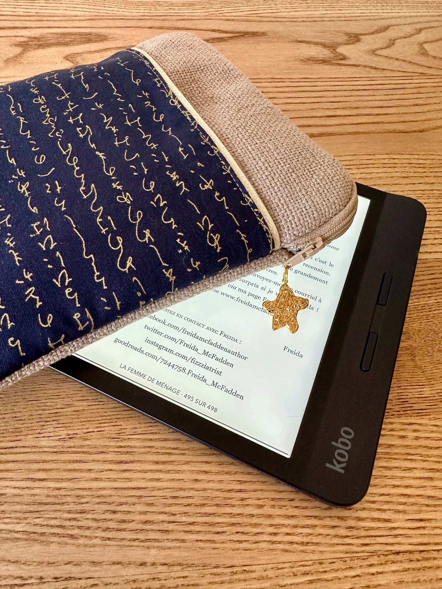 L'ouverture élargie de la pochette liseuse en lin et tissu japonais bleu à écriture dorée.
