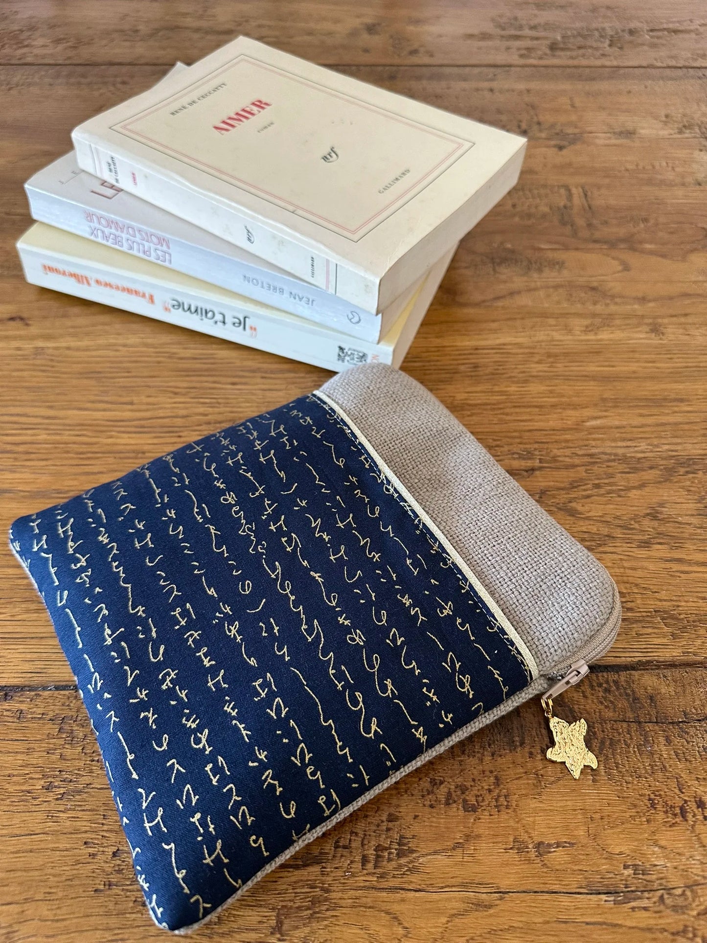 La pochette liseuse en lin et tissu japonais bleu à écriture dorée.