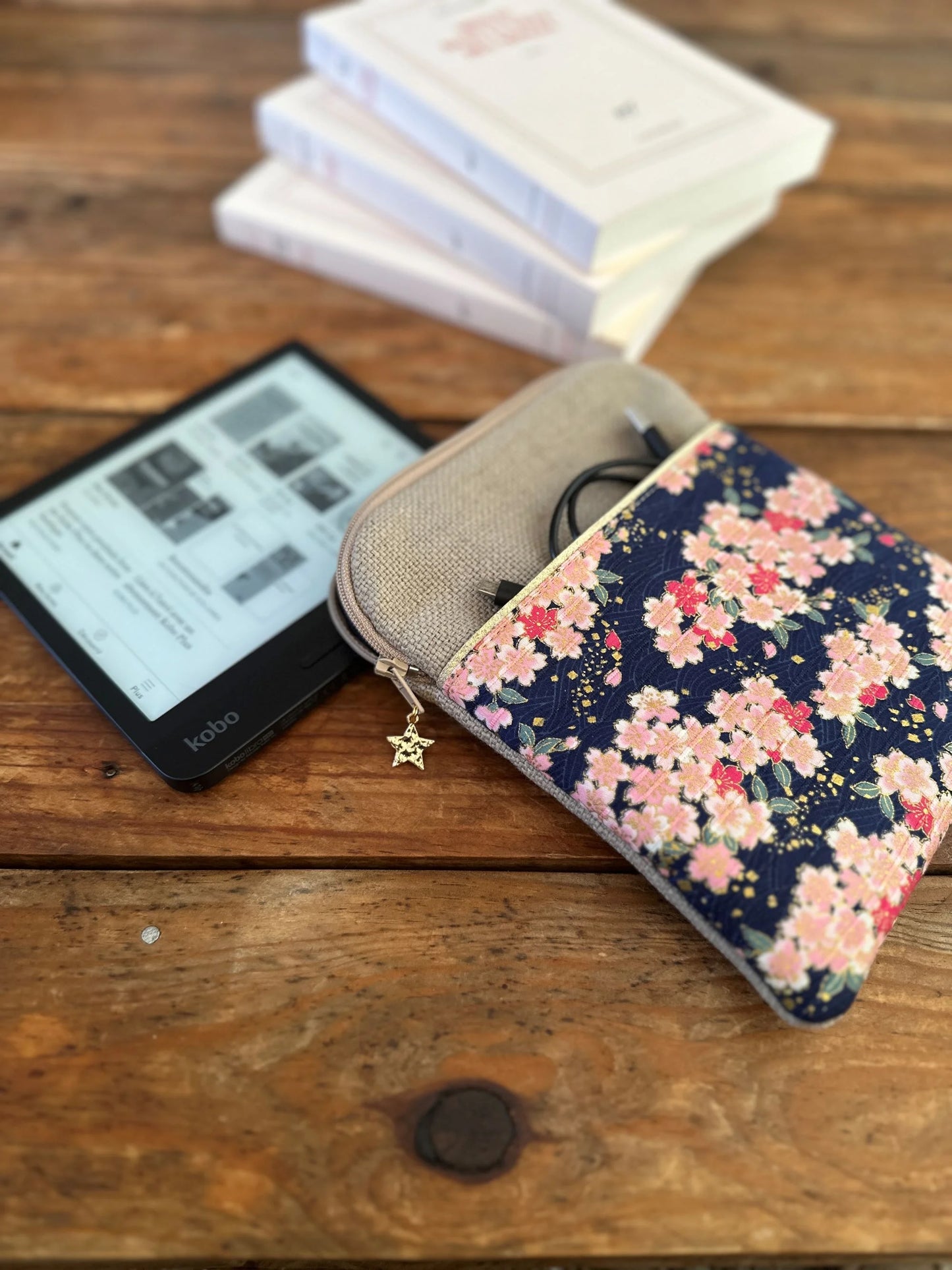 La pochette liseuse en lin et tissu japonais Sakura fleuri, posée à coté d'une Kobo Libra.