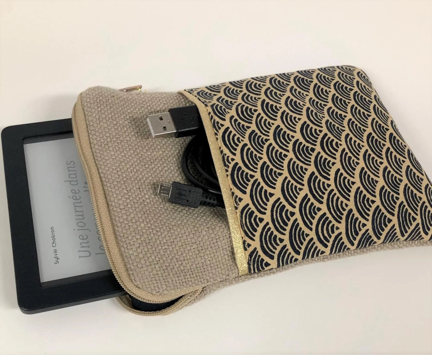 La pochette liseuse en lin et tissu japonais Seigaiha contenant la Kobo et le cable de recharge dans la poche avant.