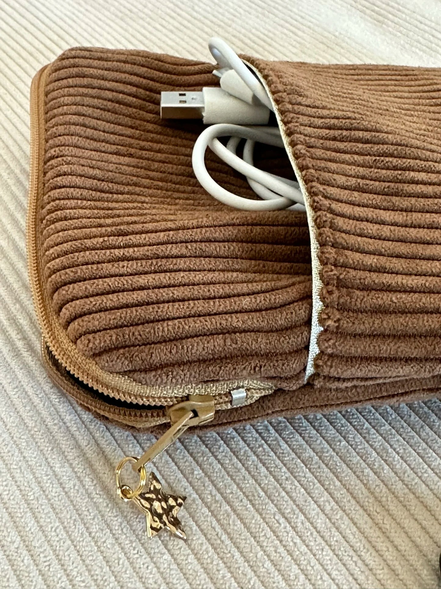 Vue détaillée de l'ouverture élargie de la pochette liseuse en velours cotelé caramel.
