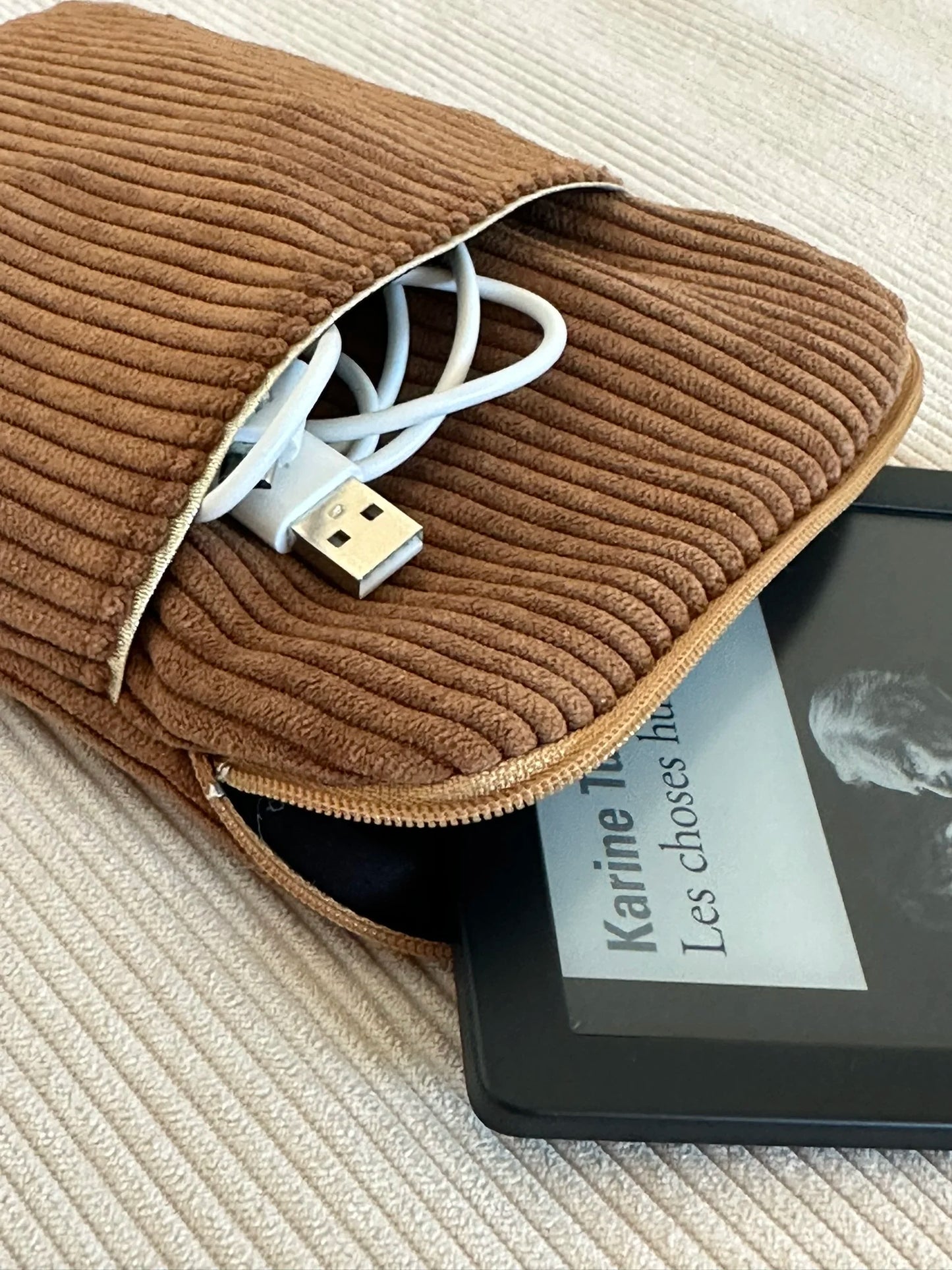 La pochette liseuse en velours cotelé caramel entrouverte.