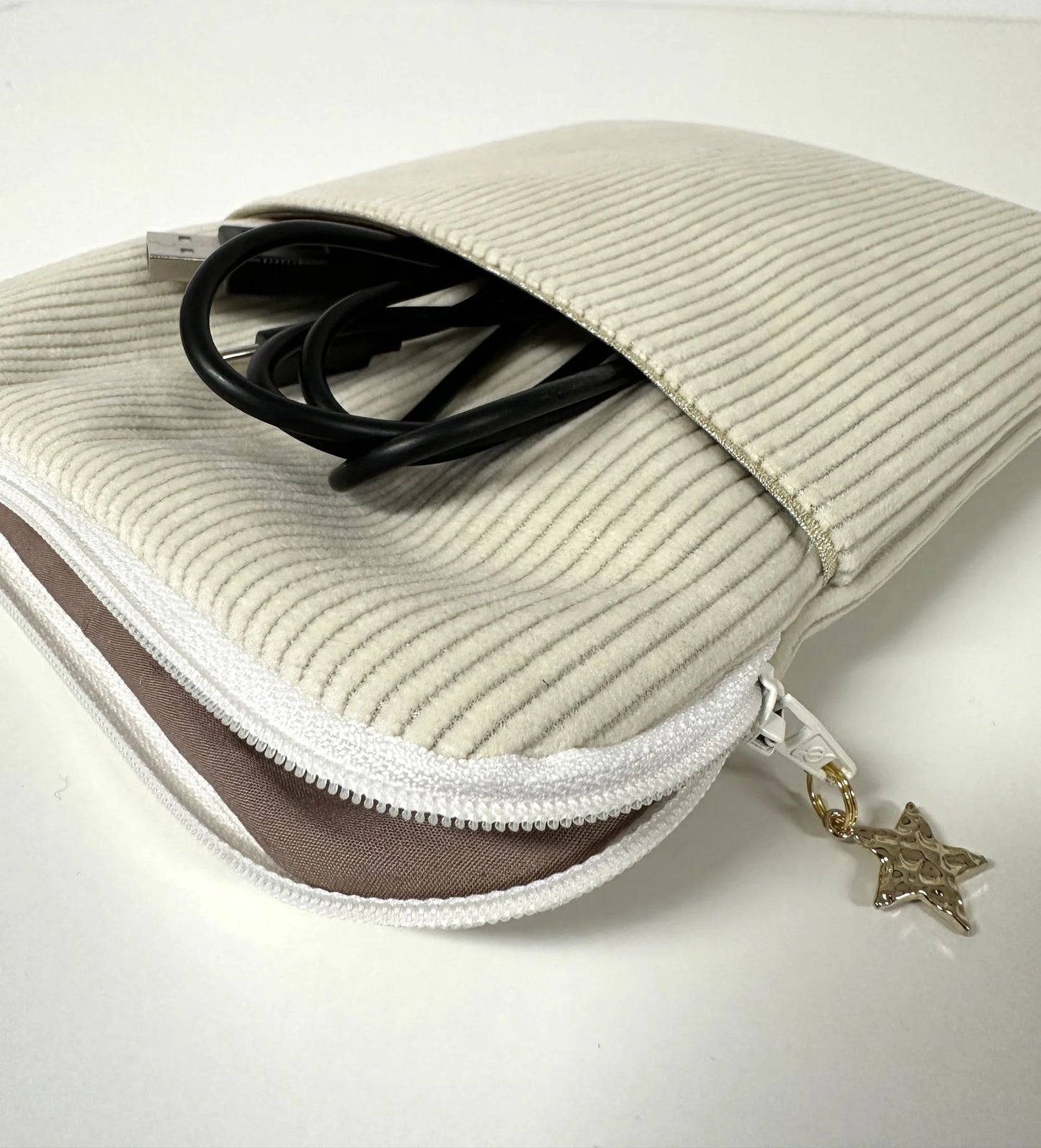 La pochette à liseuse en velours cotelé écru, ouverte.