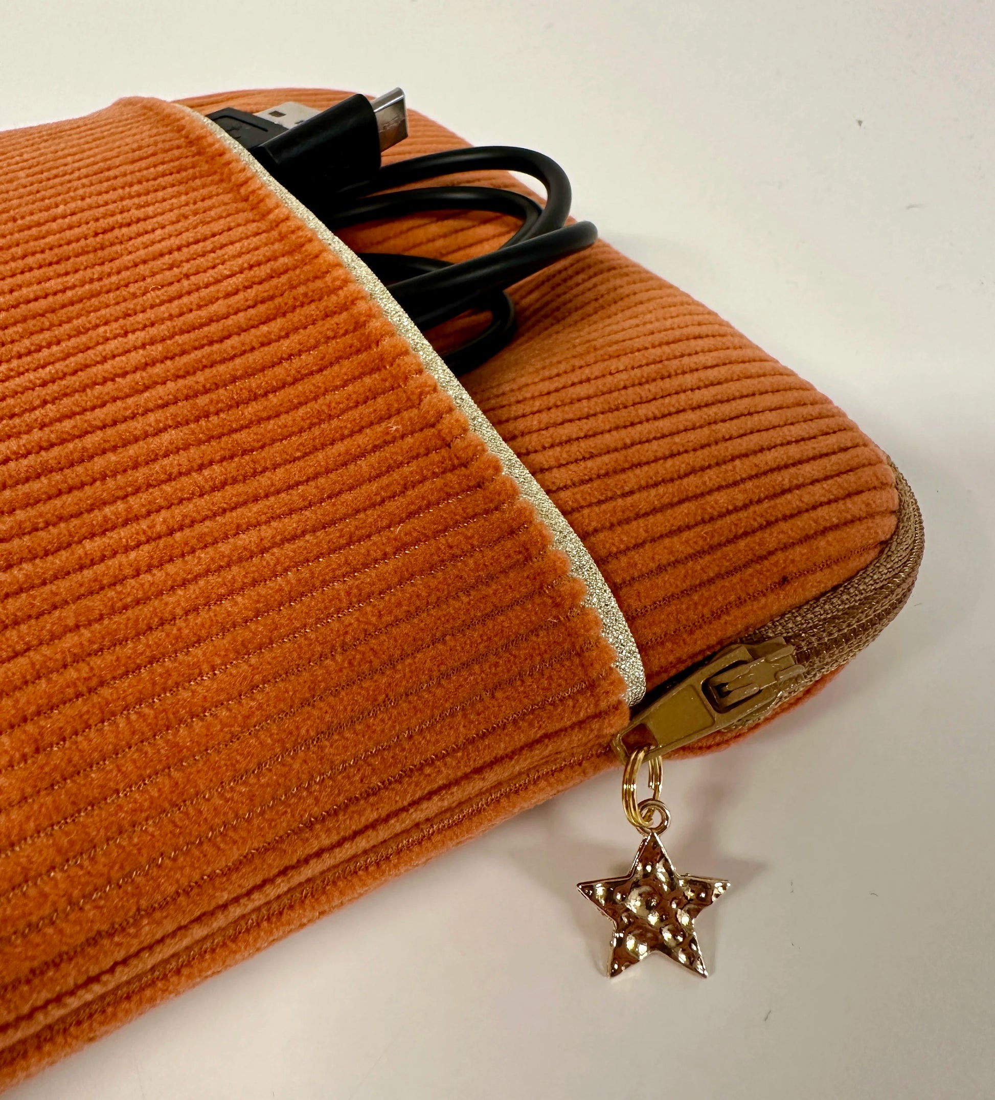 Vue détaillée de la pochette liseuse en velours cotelé orange, en face avant.