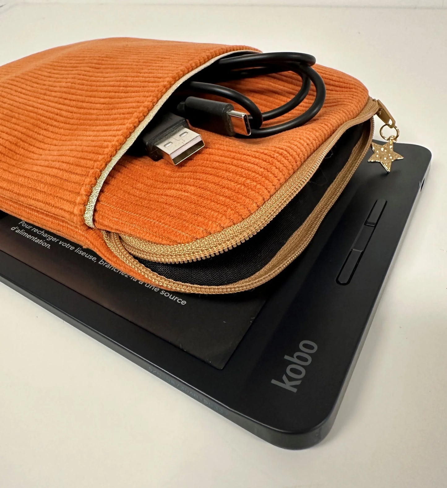 La pochette liseuse en velours orange, entrouverte.