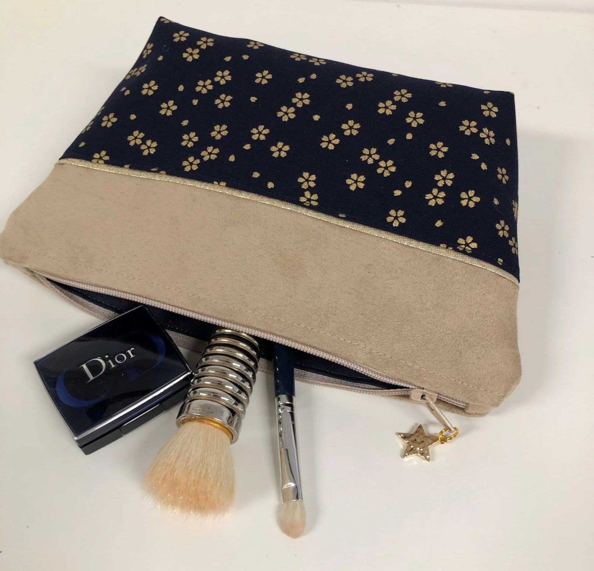 La pochette à maquillage beige en tissu japonais Sakura bleu nuit, entrouverte.