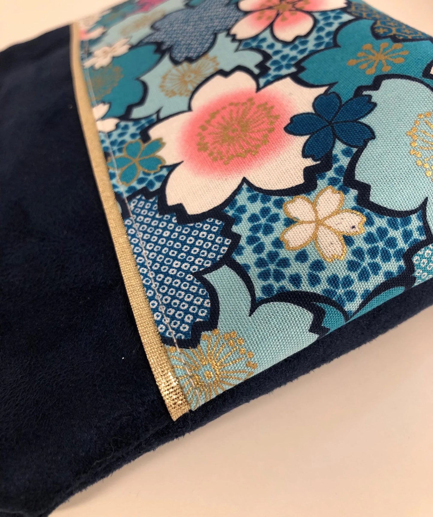 Détail de La pochette à maquillage bleu marine en tissu japonais fleuri turquoise
