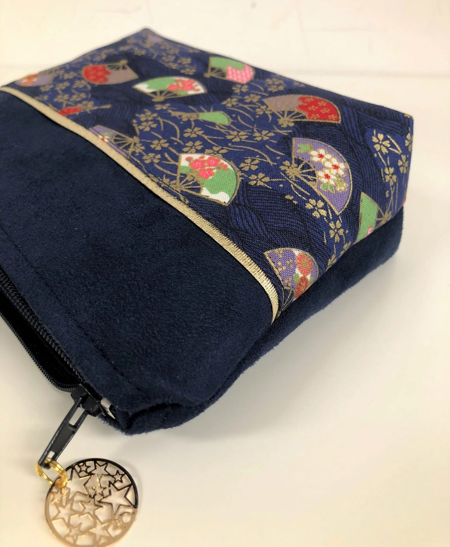 Vue latérale de La pochette à maquillage bleu marine en tissu japonais Sakura éventails