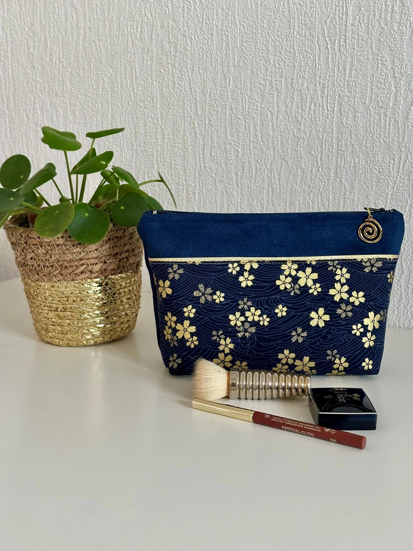 Vue d'ensemble de la pochette à maquillage fleurie bleu et dorée.
