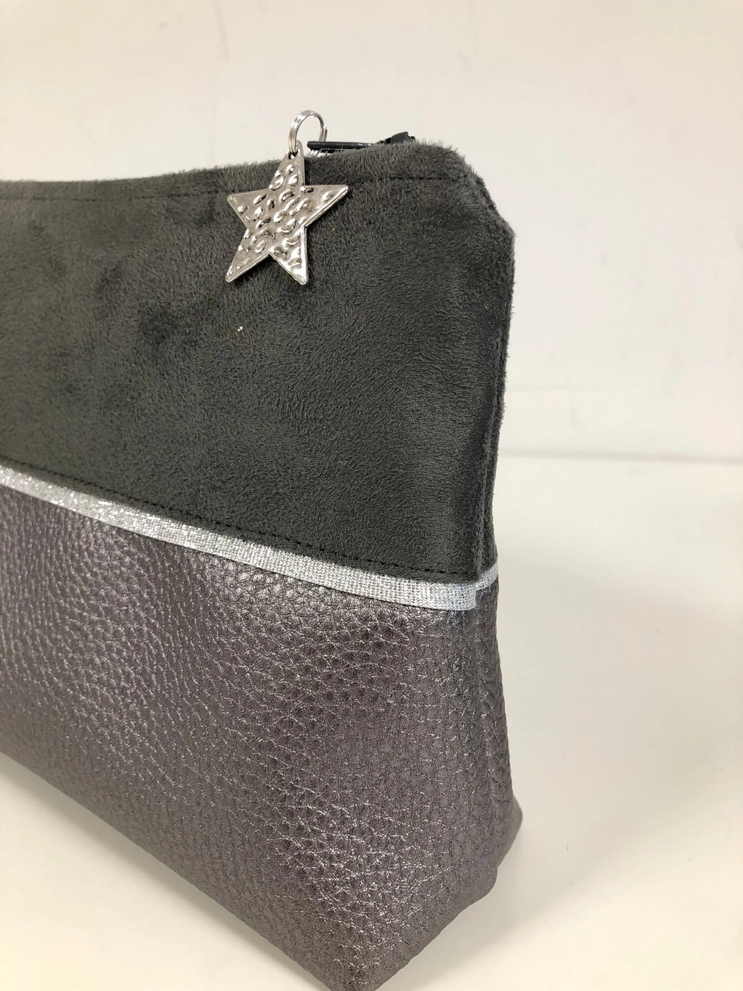 Vue détaillée de la pochette à maquillage grise et argentée.