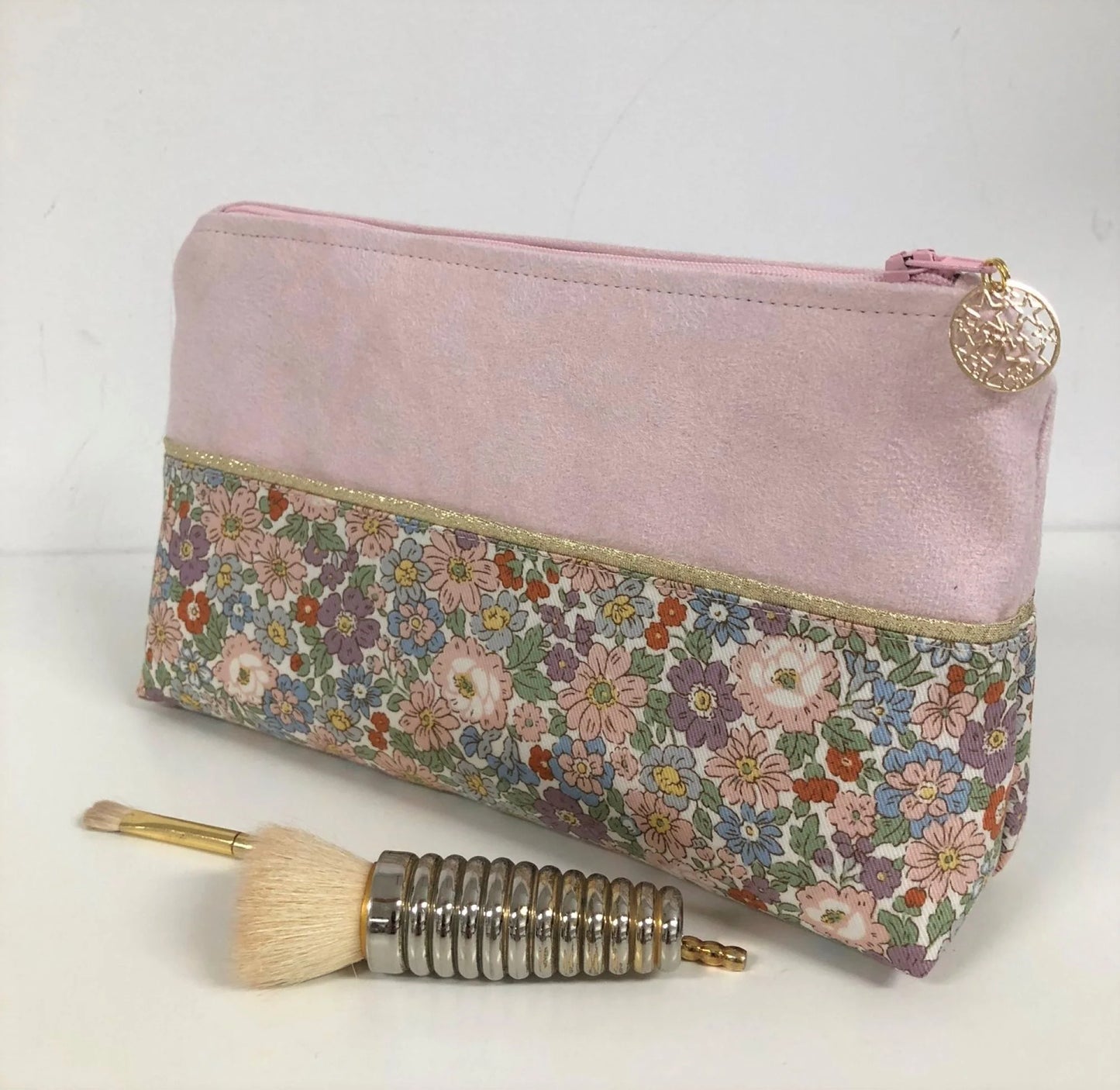 La pochette à maquillage rose et dorée à fleurs pastel, vue d'ensemble.