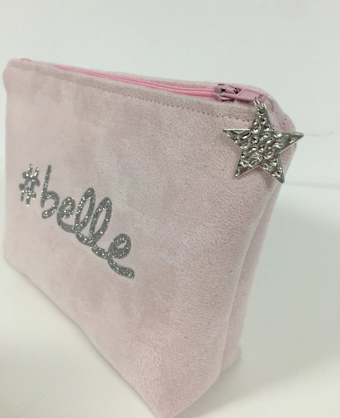 La pochette à maquillage rose pastel belle à paillettes argentées, fermée.