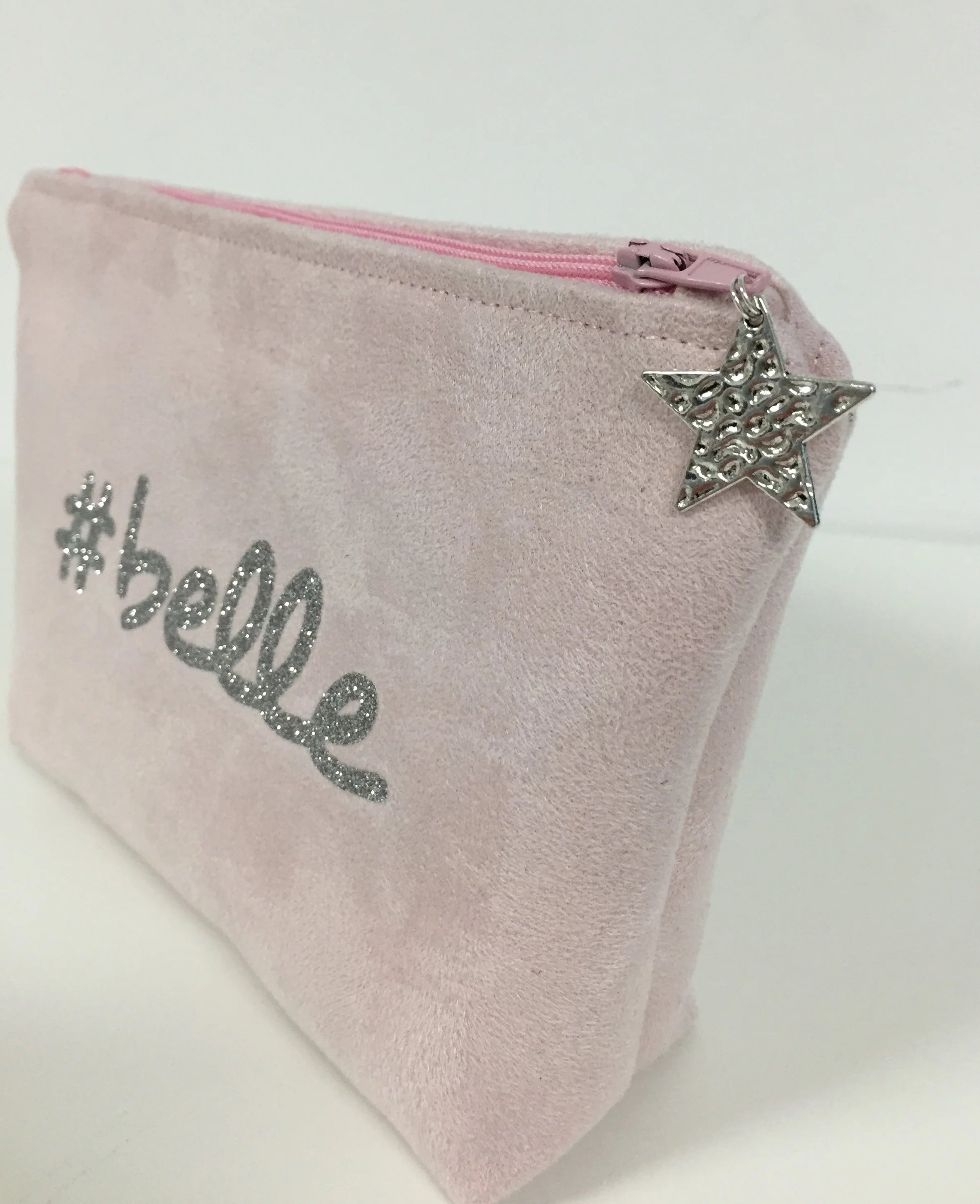 La pochette à maquillage rose pastel belle à paillettes argentées, fermée.