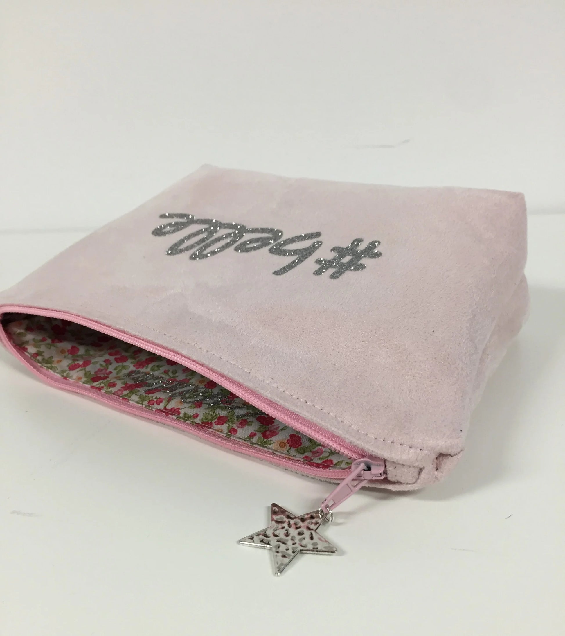 La pochette à maquillage rose pastel belle à paillettes argentées, ouverte.