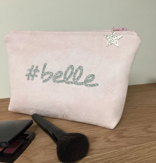 La pochette à maquillage rose pastel belle à paillettes argentées.