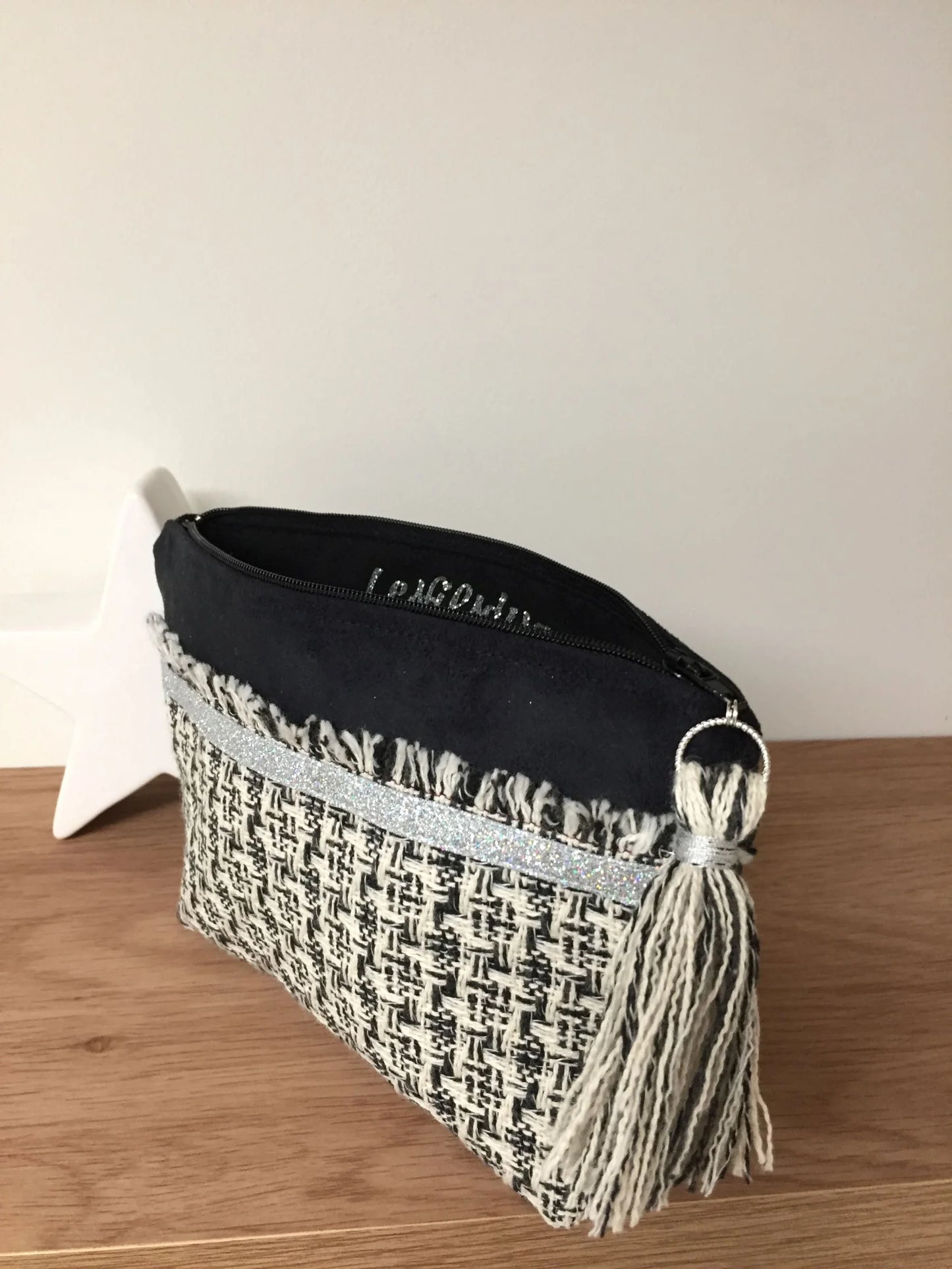 Vue ouverte de la pochette noire et écru en tweed style haute couture française.