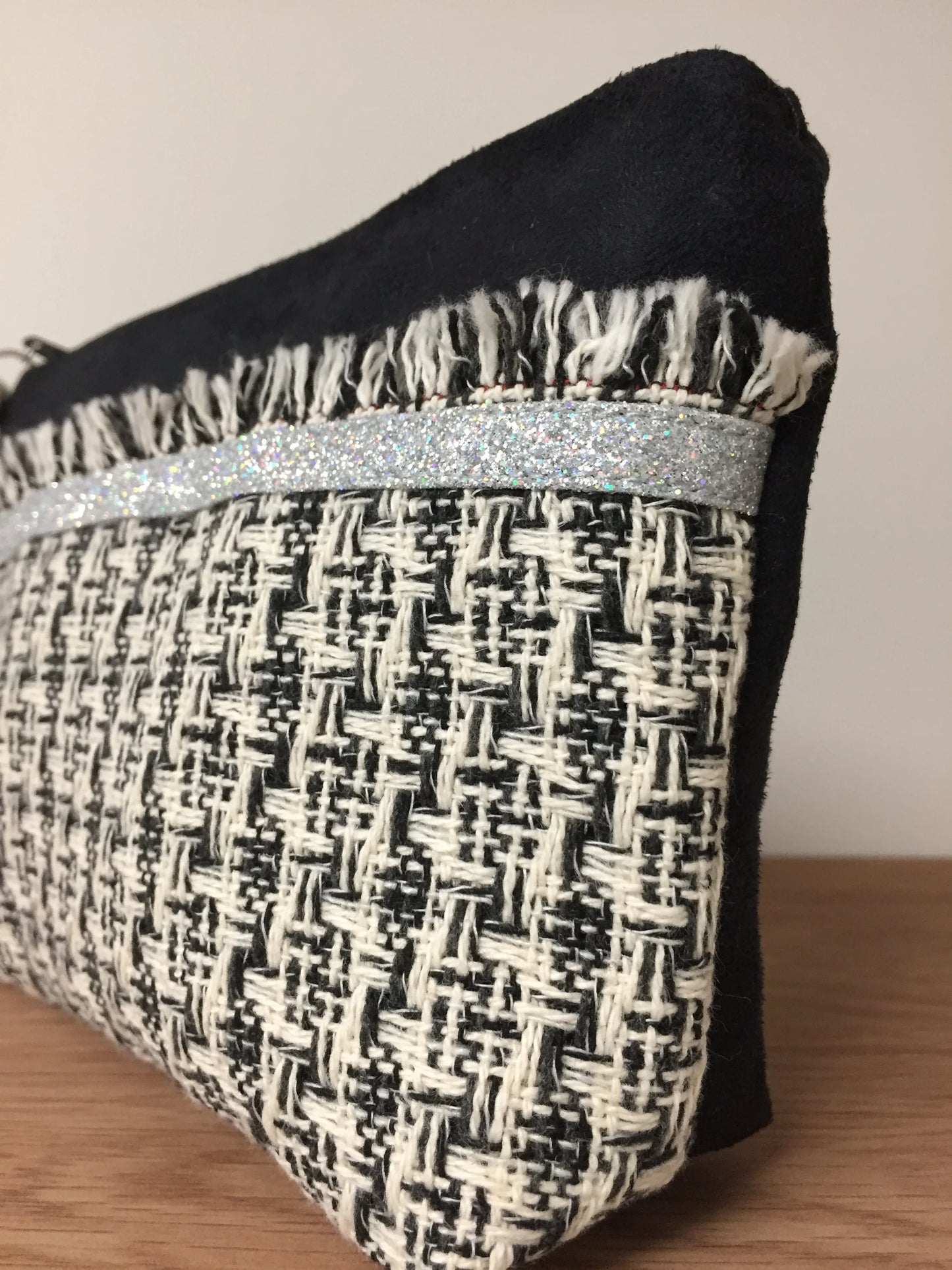 Vue détaillée de la face avant de la pochette noire et écru en tweed style haute couture française.