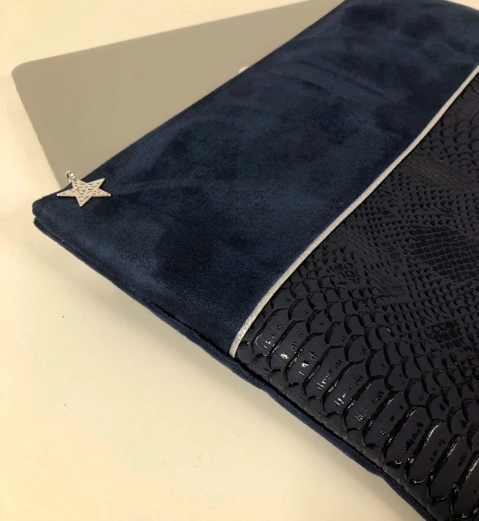 Vue détaillée de la face avant de la pochette ordinateur bleu marine et argentée aspect reptile.
