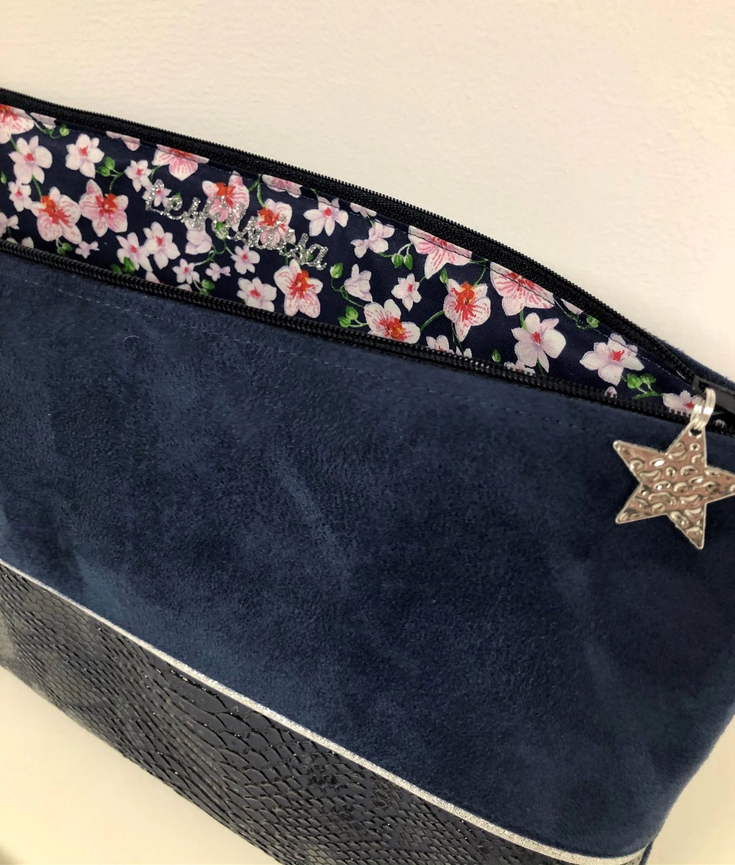 Vue ouverte de la pochette ordinateur bleu marine et argentée aspect reptile.