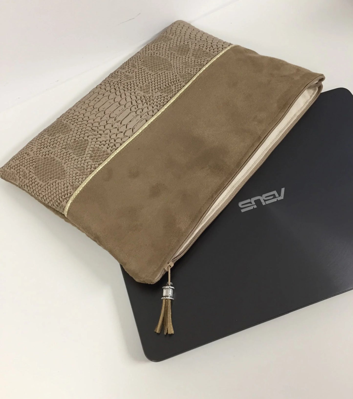 Lpochette ordinateur camel et dorée aspect reptile, posée sur PC Asus.a